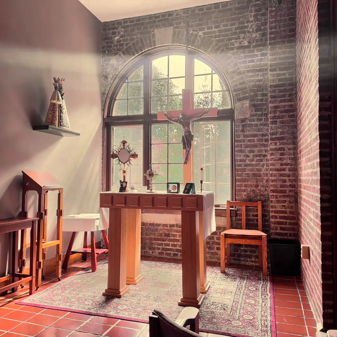 The Adoration Chapel: an arched window behind a crucifix, and the monstrance on the altar