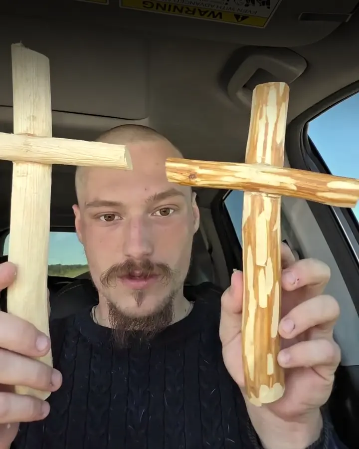 John holding up two freshly carved crosses in his car